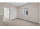 Neutral bedroom features plush carpet, bright window, and easy access to the hallway at 7437 S 75Th Dr, Laveen, AZ 85339