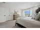 Well-lit bedroom showcasing a neutral palette, dresser with round mirror, and sitting area near a bright window at 7437 S 75Th Dr, Laveen, AZ 85339