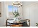 Cozy dining area featuring an elegant light fixture, round table, and natural light at 7437 S 75Th Dr, Laveen, AZ 85339
