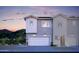 Modern two-story home with a two-car garage and light gray and white siding at dusk at 7437 S 75Th Dr, Laveen, AZ 85339