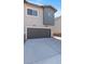 Exterior view showcasing the two-car garage with a gray door and concrete driveway at 7437 S 75Th Dr, Laveen, AZ 85339
