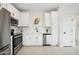 Bright kitchen with stainless steel appliances, white cabinetry, modern countertops, and tile flooring at 7437 S 75Th Dr, Laveen, AZ 85339