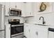 Well-equipped kitchen featuring stainless steel appliances, white cabinets, and contemporary countertops at 7437 S 75Th Dr, Laveen, AZ 85339