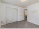 Bedroom featuring gray wood-look tile floors, a closet with sliding doors, and an open door to a bathroom at 8033 N 56Th Ave, Glendale, AZ 85302