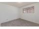 A bedroom with gray wood-look tile floors, white brick walls, and a window letting in natural light at 8033 N 56Th Ave, Glendale, AZ 85302