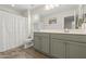 Bathroom with green cabinets, double sinks, large mirror, and white countertops at 8343 E Irwin Ave, Mesa, AZ 85209