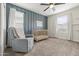 Bedroom with a blue accent wall, glider chair, crib, and natural light at 8343 E Irwin Ave, Mesa, AZ 85209