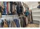 Walk-in closet with built-in shelving and hanging rods filled with clothing at 8343 E Irwin Ave, Mesa, AZ 85209