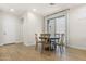 Bright dining room with a round wooden table set, wood-look tile floors, and a sliding glass door to the backyard at 8343 E Irwin Ave, Mesa, AZ 85209