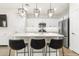 A modern kitchen features white cabinets, stainless steel appliances, pendant lights, and an island with seating at 8343 E Irwin Ave, Mesa, AZ 85209
