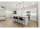 Open kitchen features white cabinets, stainless steel appliances, pendant lighting and an island with bar stool seating at 8343 E Irwin Ave, Mesa, AZ 85209