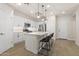 Well-lit modern kitchen boasts white cabinetry, stainless steel appliances, and a quartz countertop island with seating at 8343 E Irwin Ave, Mesa, AZ 85209