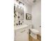 Stylish half-bath with updated fixtures, modern lighting, and a classic white vanity and toilet at 8425 E Bonnie Rose Ave, Scottsdale, AZ 85250