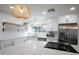 Bright kitchen features stainless steel appliances, white cabinets, countertops, tile backsplash, and attractive pendant lighting at 8425 E Bonnie Rose Ave, Scottsdale, AZ 85250