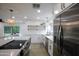 Open concept kitchen featuring stainless steel appliances, white cabinets and countertops, and view into the living room at 8425 E Bonnie Rose Ave, Scottsdale, AZ 85250