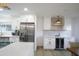Bright kitchen features stainless steel appliances, white cabinets, countertops and backsplash with a wine fridge on one side at 8425 E Bonnie Rose Ave, Scottsdale, AZ 85250