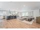 Bright open floorplan with hardwood floors, modern furnishings, and a kitchen island with barstool seating at 8455 E Orange Blossom Ln, Scottsdale, AZ 85250
