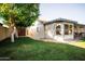 Spacious backyard with lush green grass, mature trees, and covered patio with outdoor seating at 919 W Lodge Dr, Tempe, AZ 85283
