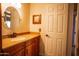 Bathroom featuring vanity with traditional cabinets and a circular mirror next to a white door at 919 W Lodge Dr, Tempe, AZ 85283