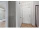 Hallway, tile floor and white door; view into bathroom with glass shower at 9820 N Central Ave # 224, Phoenix, AZ 85020