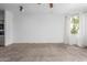 Bright living room featuring neutral tones, a ceiling fan, and a large window at 9820 N Central Ave # 224, Phoenix, AZ 85020