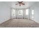 Bright living room with neutral carpet, ceiling fan, and a door that leads to a balcony with great views at 9820 N Central Ave # 224, Phoenix, AZ 85020