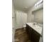 Well-lit bathroom with a single sink vanity, decorative countertop, and shower with curtain at 10231 E Illini St, Mesa, AZ 85208