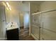 Bathroom with double sinks, a large mirror, and a glass-enclosed shower at 10231 E Illini St, Mesa, AZ 85208