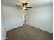A spacious bedroom with neutral carpet, a ceiling fan, and a door to another room at 10231 E Illini St, Mesa, AZ 85208