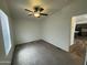 Bright bedroom with plush carpet, ceiling fan, and an open door leading to kitchen area at 10231 E Illini St, Mesa, AZ 85208