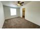 Cozy bedroom featuring a ceiling fan and a window for natural light, and a walk-in closet at 10231 E Illini St, Mesa, AZ 85208