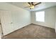 A cozy bedroom features neutral carpet, a ceiling fan, and a window for natural light at 10231 E Illini St, Mesa, AZ 85208