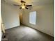 Bright, carpeted bedroom with a ceiling fan and a window providing natural light at 10231 E Illini St, Mesa, AZ 85208