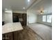 Modern kitchen with dark wood cabinets, an island, tile floor, and open to the living room at 10231 E Illini St, Mesa, AZ 85208