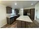 Modern kitchen featuring dark cabinets, stainless steel appliances, a kitchen island, and tile floors at 10231 E Illini St, Mesa, AZ 85208