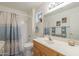 Well-lit bathroom with a vanity, tub, and shower combination at 11012 E Knowles Ave, Mesa, AZ 85209
