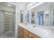 A bright bathroom shows a large vanity, a walk-in closet, and a view of the walk-in shower at 11012 E Knowles Ave, Mesa, AZ 85209