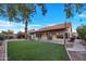 Expansive backyard showcasing a lush artificial lawn, covered patio, and mature palm trees at 1142 E Encinas Ave, Gilbert, AZ 85234