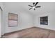 An empty bedroom with wood floors, ceiling fan, two windows, and white walls at 1142 E Encinas Ave, Gilbert, AZ 85234