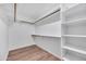 Walk-in closet with custom shelving and hardwood floors at 1142 E Encinas Ave, Gilbert, AZ 85234