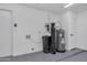A clean garage with a water heater, water softener, white walls and a gray epoxy floor at 1142 E Encinas Ave, Gilbert, AZ 85234
