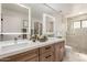 Bright bathroom featuring a double vanity with backlit mirrors, a walk-in shower, and stylish finishes at 12 E Seminole Dr, Phoenix, AZ 85022