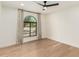 Minimalist bedroom design with a ceiling fan, hardwood flooring, and an arched window with natural light at 12 E Seminole Dr, Phoenix, AZ 85022