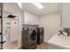 Well-organized laundry room featuring modern washer and dryer units, overhead cabinets, and ample counter space at 12 E Seminole Dr, Phoenix, AZ 85022