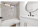 Updated bathroom features a new vanity, large mirror and tiled walls around the tub and shower at 15715 W Cottonwood St, Surprise, AZ 85374