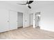 This bedroom is roomy, featuring a bathroom and closet with white doors and light wood floors at 15715 W Cottonwood St, Surprise, AZ 85374