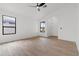 Spacious bedroom with wood-look tile, two windows, and a ceiling fan at 15715 W Cottonwood St, Surprise, AZ 85374