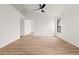 A simple, clean bedroom with wood-look tile, a window, and a ceiling fan at 15715 W Cottonwood St, Surprise, AZ 85374