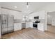 Bright kitchen featuring stainless steel appliances, white cabinets, and wood-look flooring at 15715 W Cottonwood St, Surprise, AZ 85374