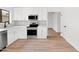 Bright kitchen featuring stainless steel appliances, white cabinets, and wood-look flooring at 15715 W Cottonwood St, Surprise, AZ 85374